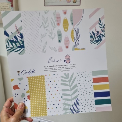 Folha de papel decorativo com padrões coloridos e texto em espanhol e inglês