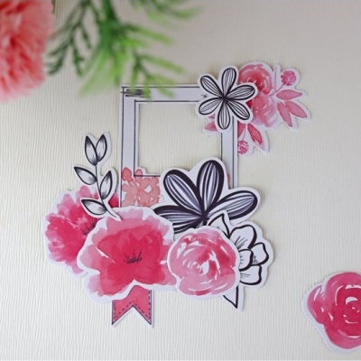 Adesivos de flores rosa, vermelho e preto em fundo branco texturizado