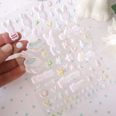 Folha de autocolantes com desenhos de coelhos e elementos decorativos em tons pastel