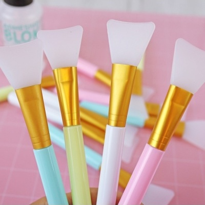 Quatro pincéis de silicone para cosméticos com cabos coloridos e ponta branca fosca