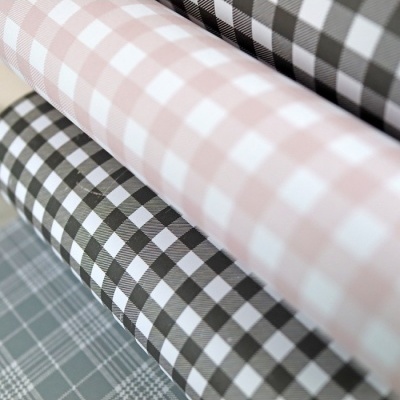 Rolos de tecido xadrez em tons bege, preto e cinza