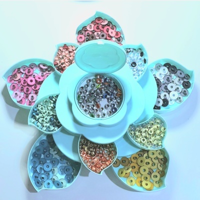 Pequenos discos coloridos em recipientes azuis formando uma flor