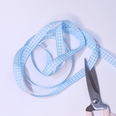 Fita decorativa azul clara xadrez com tesoura rosa