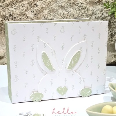 Caixa decorativa branca com desenho de coelho em relevo e padrão floral verde