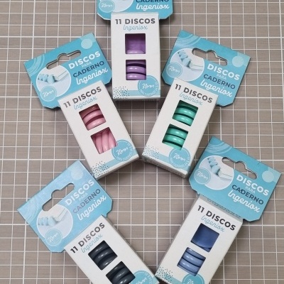 Pacotes coloridos de discos para caderno Ingeniox sobre mesa quadriculada