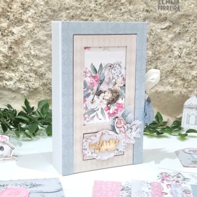 Livro ou caixa decorativa com ilustração de pássaro e flores, texto 'love home', fundo cinza e bege