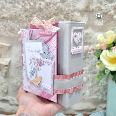 Capa de livro rosa e cinza com decoração em tecido, renda, pássaro amarelo e textos decorativos