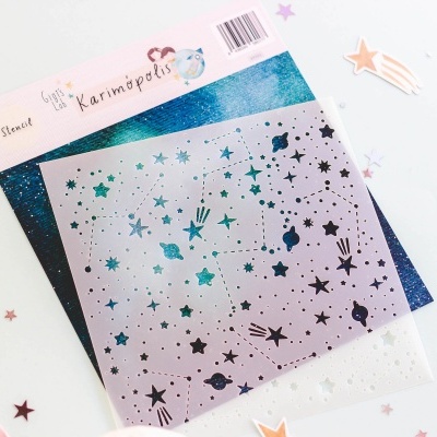 Stencil prateado com padrão de estrelas e planetas sobre fundo brilhante azul e verde