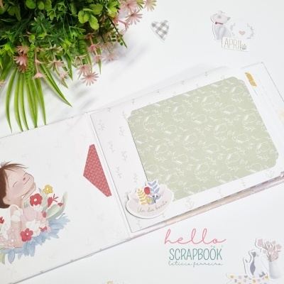 Livro de scrapbook decorado com ilustrações e flores, com plantas verdes ao lado