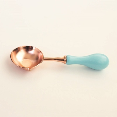 Colher de metal com cabo azul claro sobre fundo branco