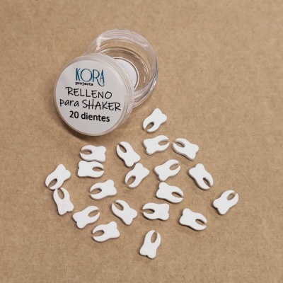 Frasco transparente com tampo e pequenos itens brancos em forma de dentes sobre superfície castanha