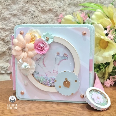 Álbum decorativo com flores e círculo transparente com patins desenhados