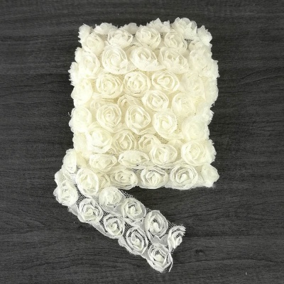 Fita branca decorativa com flores de tecido sobre madeira escura