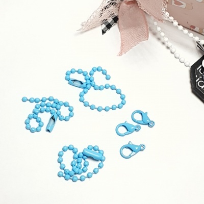 Correntes e molas azuis claras sobre superfície branca com elementos decorativos