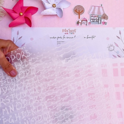 Folha translúcida com letras brancas e desenhos em fundo rosa