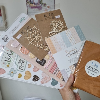 Vários artigos de artesanato e papelaria com autocolantes, recortes de madeira e bloco de papéis decorativos
