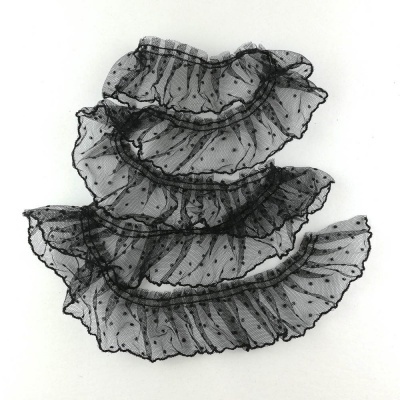 Tecido preto transparente com pontos e babados sobre fundo branco