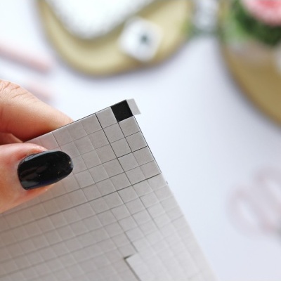 Mão segura régua de papel quadriculado branca com quadrículas cinza