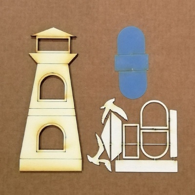 Peças em madeira para montagem de farol e gaivotas sobre superfície castanha