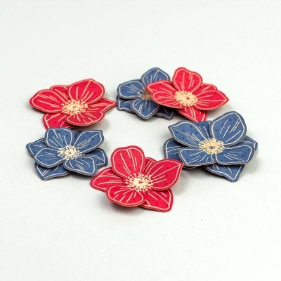 Flores decorativas em tecido vermelho e azul com detalhes dourados, dispostas em círculo