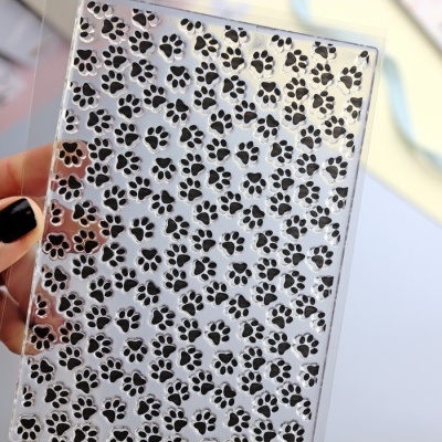 Estampa transparente com padrão de pegadas de patas pretas.