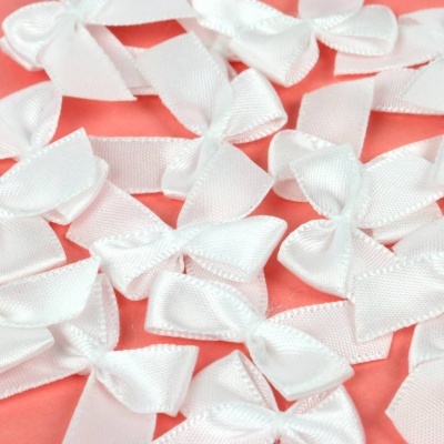 Fitinhas brancas em formato de laço sobre fundo rosa