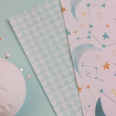 tecidos ou papéis decorativos com padrões de triângulos e constelações sobre fundo azul