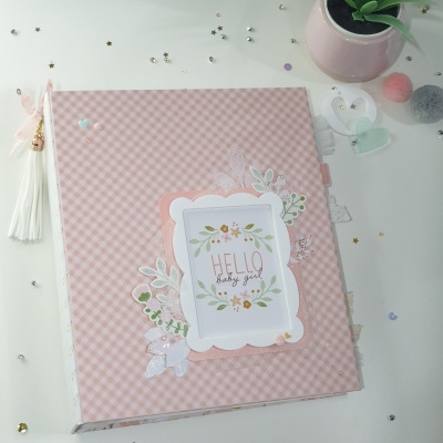 Álbum rosa xadrez com decoração floral e texto 'HELLO baby girl'