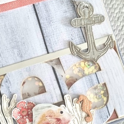 Scrapbook temático marinho com âncora, peixe e elementos em papel