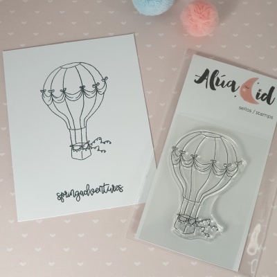 Selo de silicone transparente em forma de balão ao lado de cartão com desenho do balão e texto springadventures