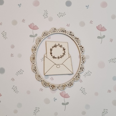 Quadro decorativo com envelope e cartão ilustrado em moldura rendilhada sobre papel de parede floral