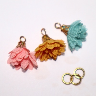 Três pendentes florais de tecido e fechos metálicos com três anéis metálicos ao lado