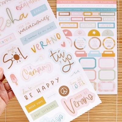 Folhas de autocolantes com palavras e frases em espanhol em cores suaves sobre superfície de madeira clara