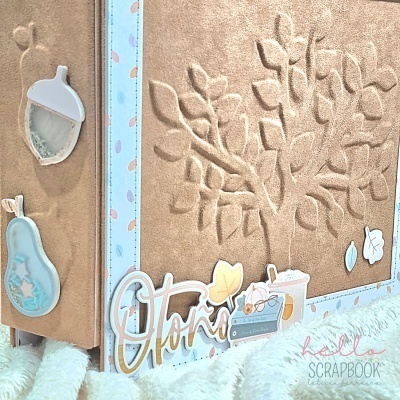 Caderno scrapbook castanho com relevo de árvore e decoração de outono em azul e castanho.