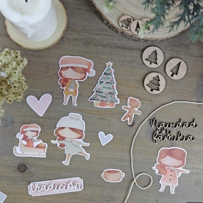 Recortes de papel de personagens infantis e decoração natalina sobre mesa de madeira