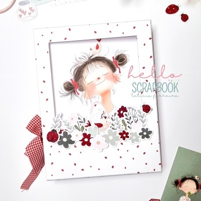 Álbum de scrapbook com capa ilustrada de menina e flores em fundo branco com bolinhas vermelhas