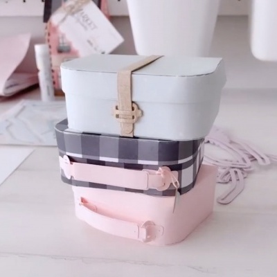 Três caixas retangulares empilhadas com diferentes cores e padrões em fundo branco