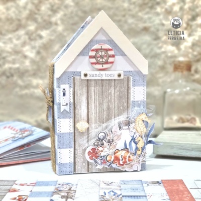 casinha decorativa azul e branca com porta de madeira e decoração marítima