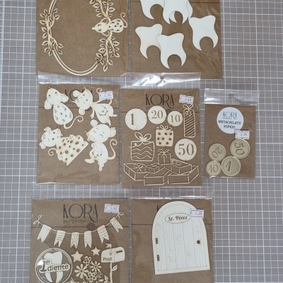 Conjunto de recortes decorativos de madeira clara em embalagem transparente com fundo castanho