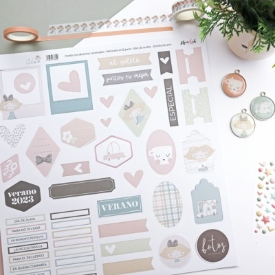 Folha com autocolantes de scrapbooking em cores pastel com texto em espanhol e decoração ao redor