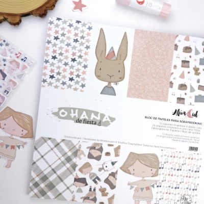 Bloco de papéis de scrapbook com desenhos infantis e padrões variados em tons pastel.