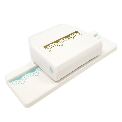 Perfurador de papel branco com padrão rendado em papel azul