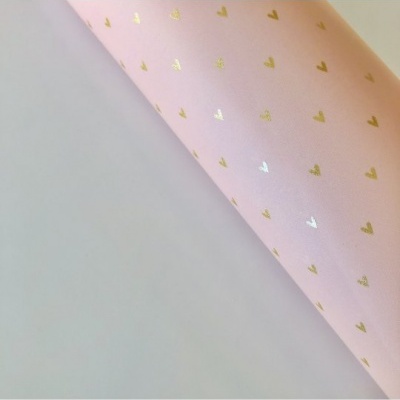 Papel de embrulho rosa com corações dourados