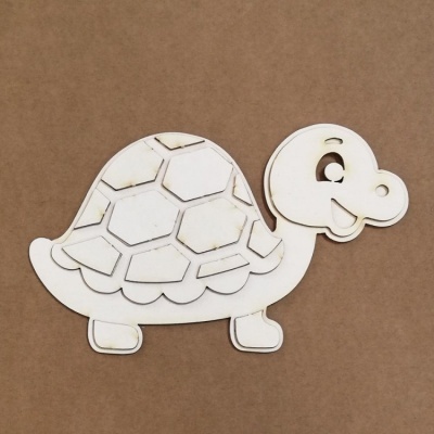 Figura de tartaruga em madeira com padrões hexagonais recortados na carapaça