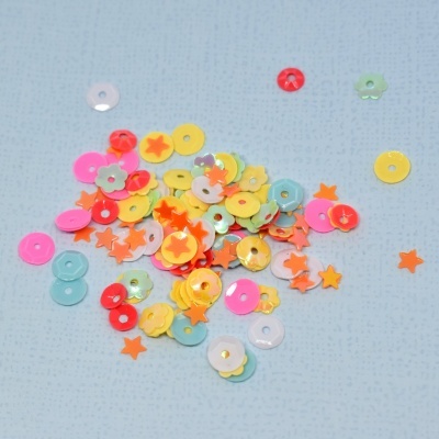 Lantejoulas coloridas variadas em fundo azul claro