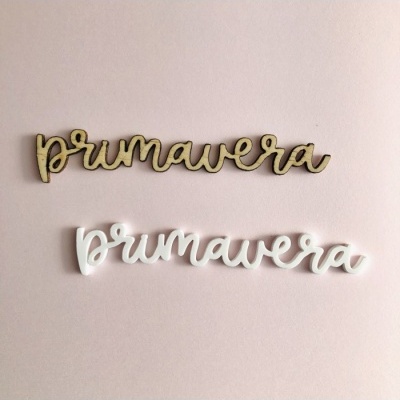 Palavras 'primavera' em madeira natural e branca sobre fundo rosa claro