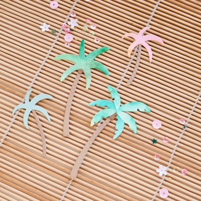 Colares com pingentes de palmeiras coloridas em superfície de ripas de madeira