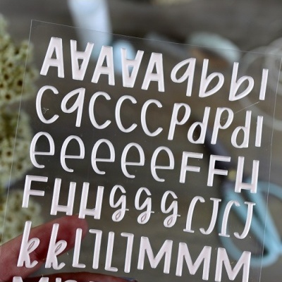 Folha transparente com autocolantes de letras brancas em vários estilos