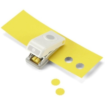 Perfurador de papel branco a criar recortes circulares em papel amarelo