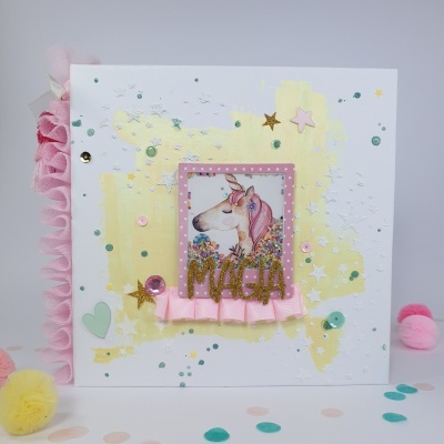 Cartão decorativo branco com unicórnio, texto MAGIA dourado, fita rosa e confetes coloridos